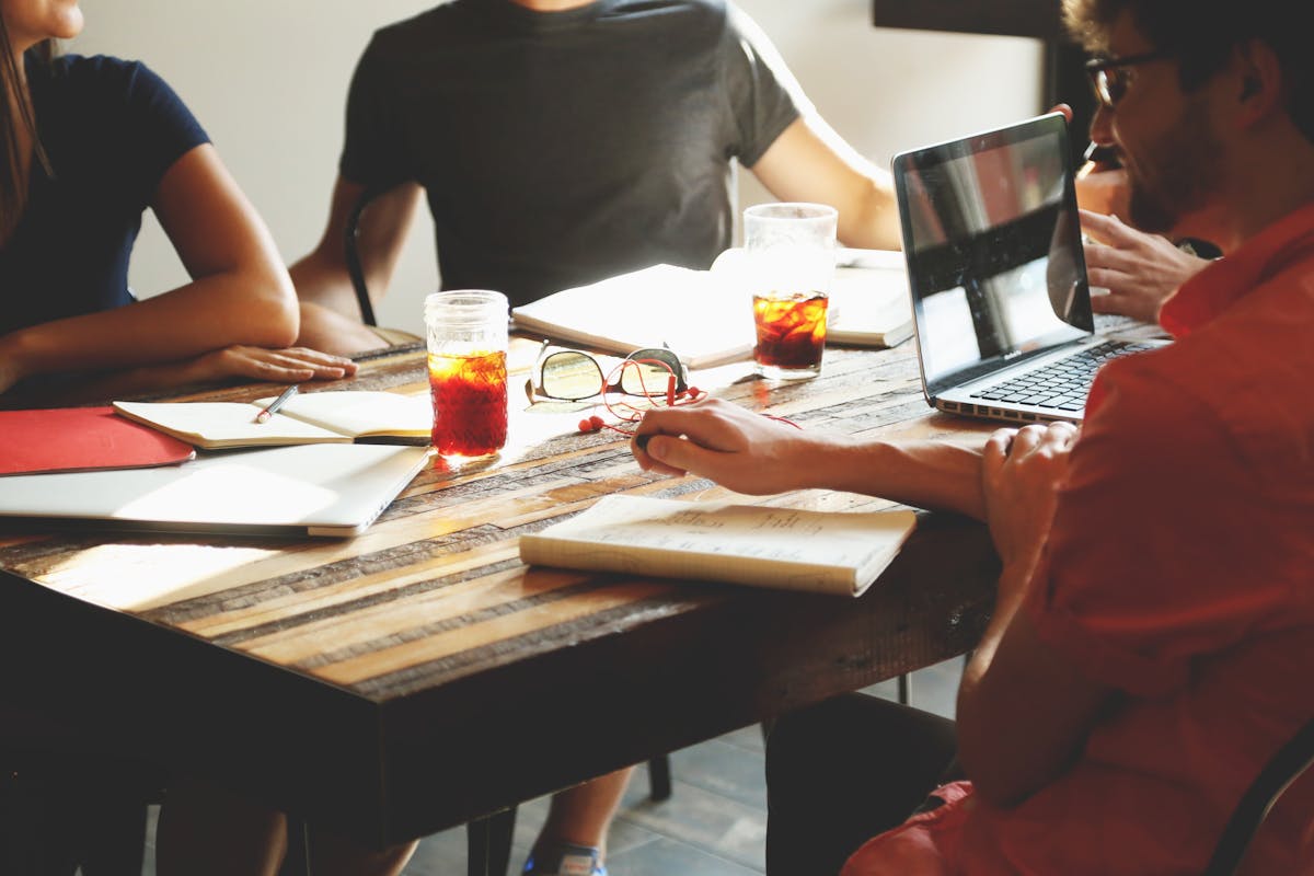 Startup team collaborating over coffee at a meeting table. Photo by Startup Stock Photos on Pexels.