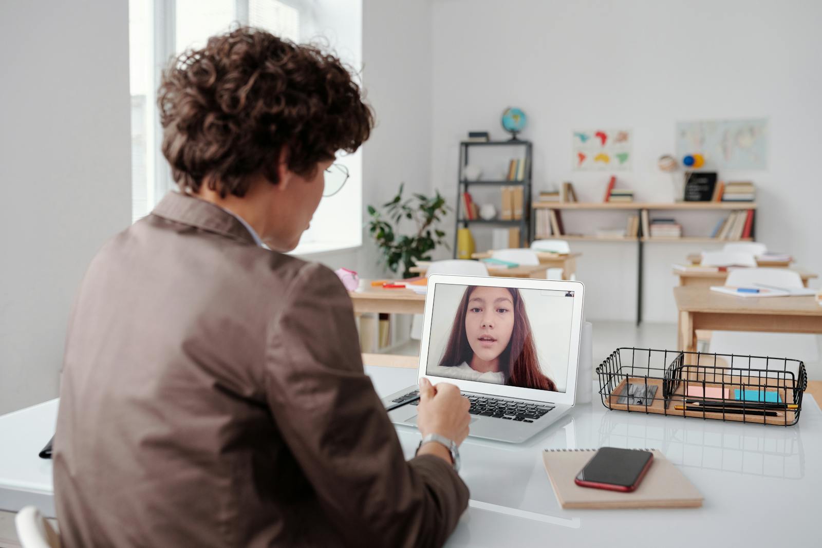 Teacher conducting an online class from a classroom using a laptop